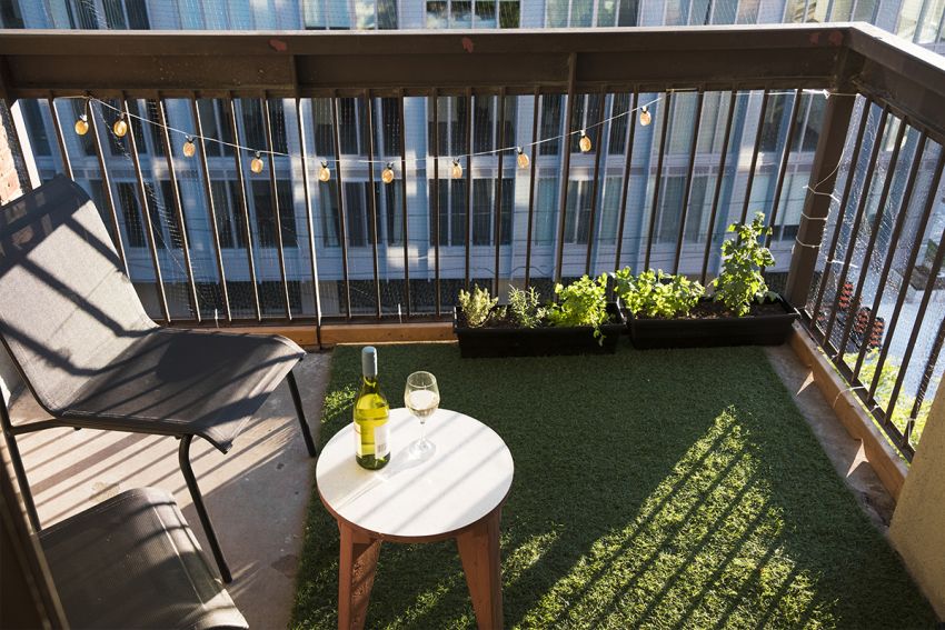 Balkon mit Sonnenlicht und Kunstrasen als Boden