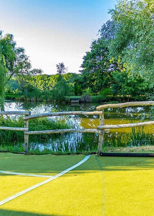 Kunstrasen weg für Pferde mit teich im hintergrund